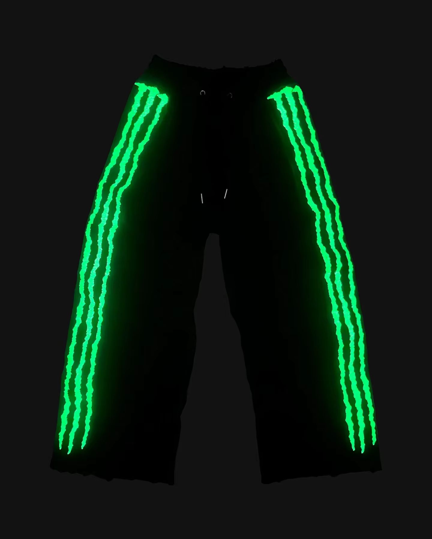 A night photo of the glowing Glow Stripe Rave Pants