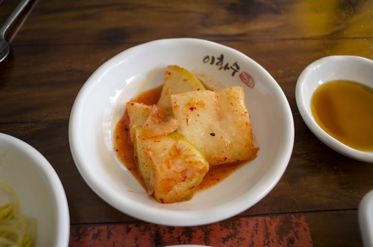 Close-up of Korean kkakdugi, diced radish kimchi, served as a side dish.