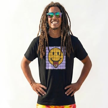 A mid shot photo of Mana proudly wearing the smiley square t-shirt