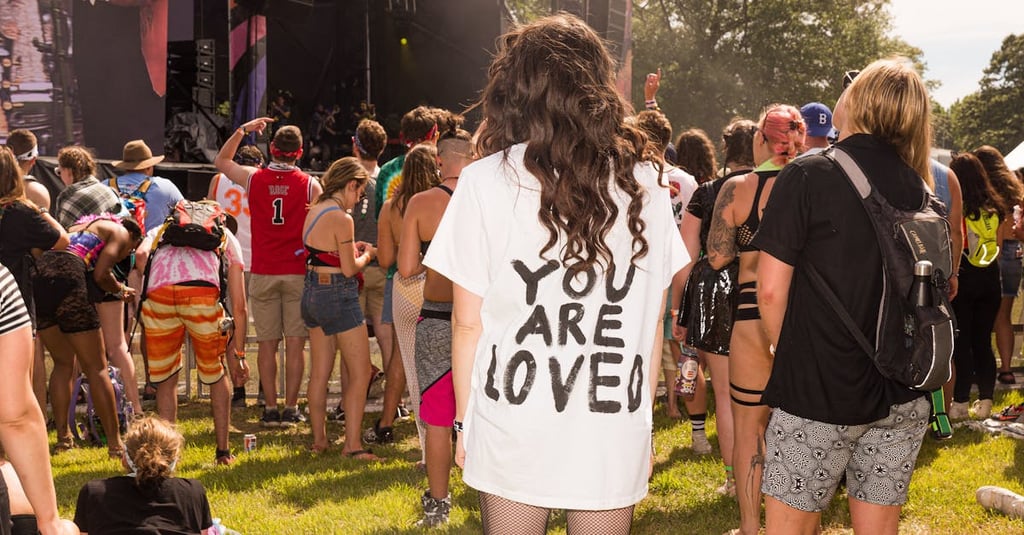 A lively festival scene with diverse people gathered outdoors enjoying a concert.
