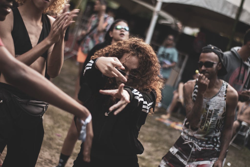 Photo by Thiago Miranda Vibrant outdoor rave scene with diverse group of young adults enjoying music and dancing